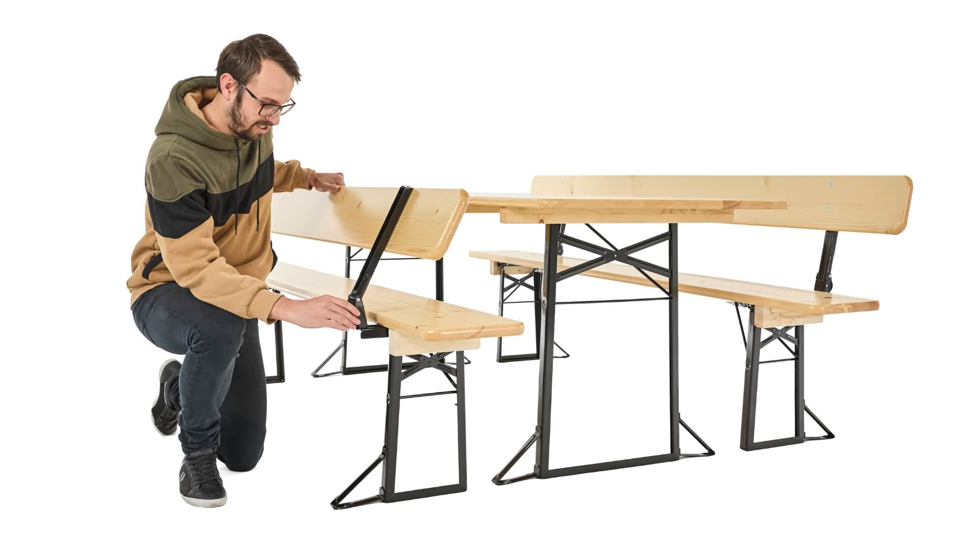 A boy presses the bolt at the back of the classic beer garden table set to be able to fold the back.