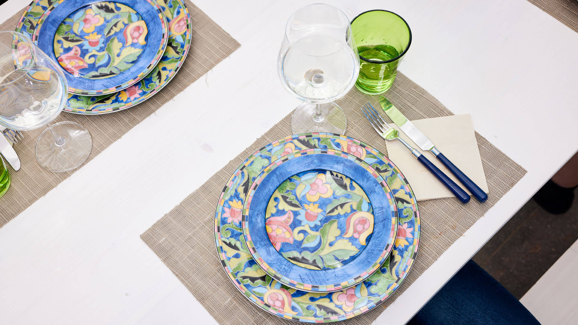 The Riva designer set has been decorated with colorful plates and glasses for the meal.