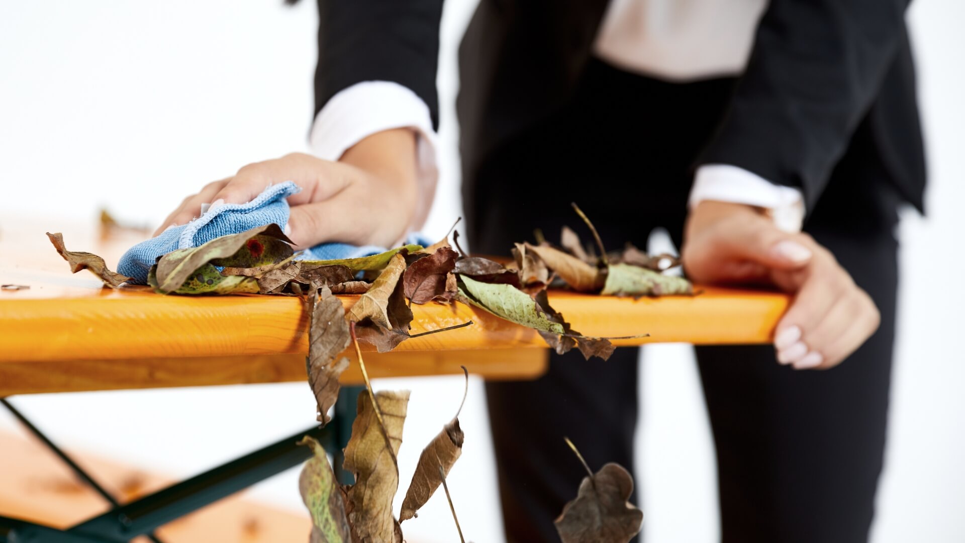 A woman removes the leaves on the beer garden table set.