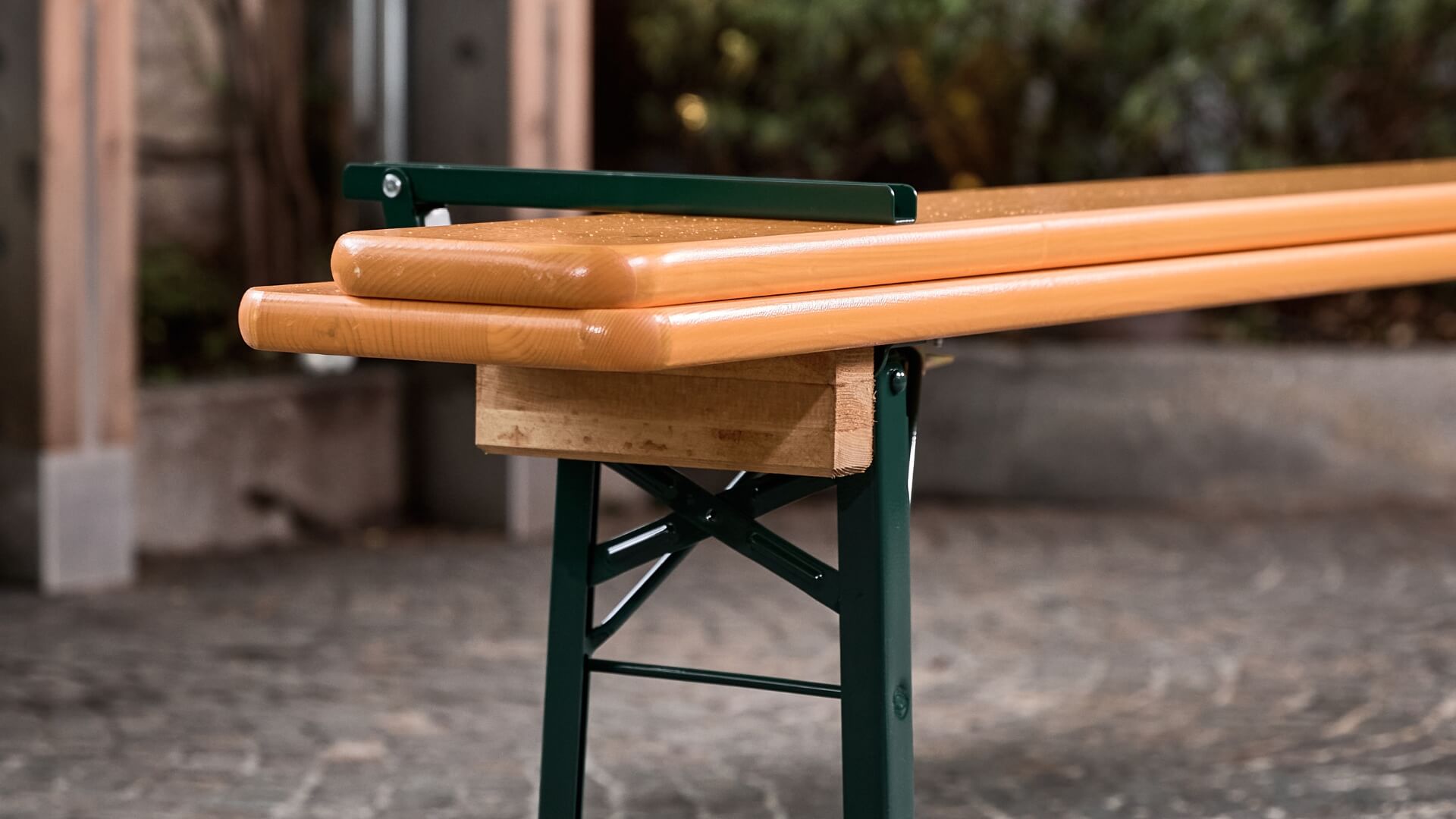 The back of a beer bench is folded in the outdoor area of a restaurant.