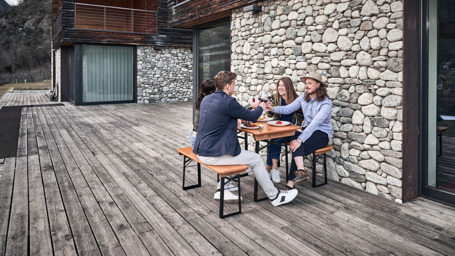 Four friends sit on the small beer garden table sets Shorty and toast together.