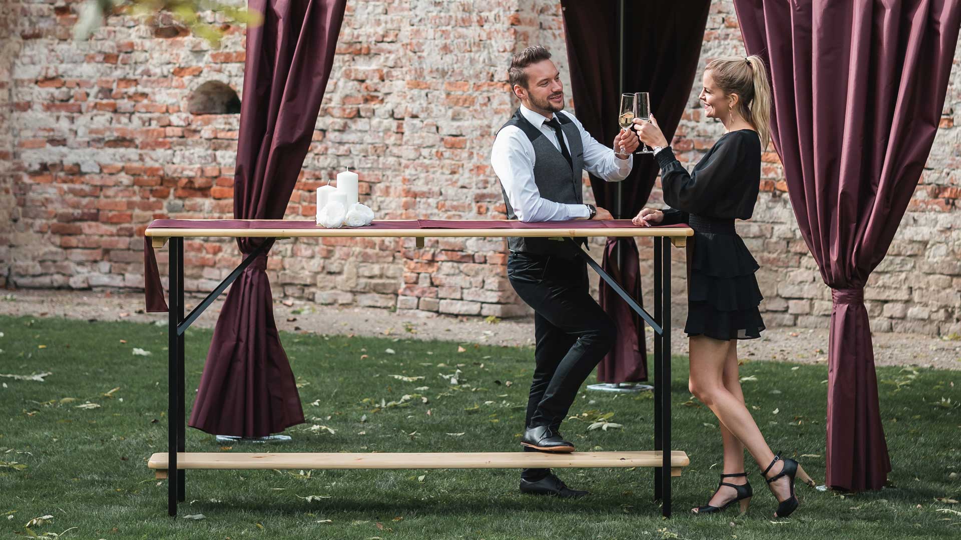 Zwei Menschen stehen mit einem Aperitif am Stehtisch.