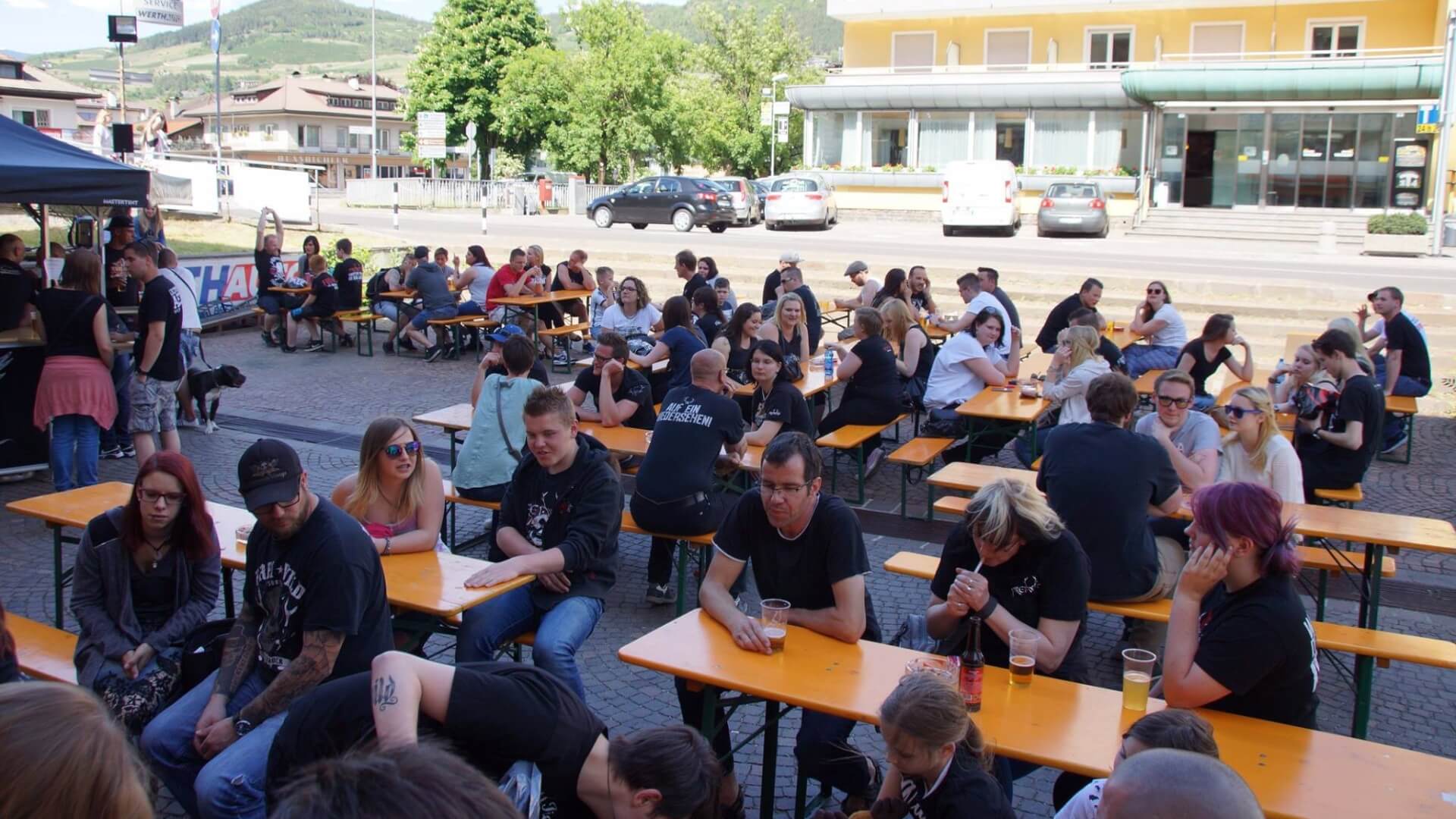  At the Rookies & Kings event, many people sit outside on beer table sets and chat.