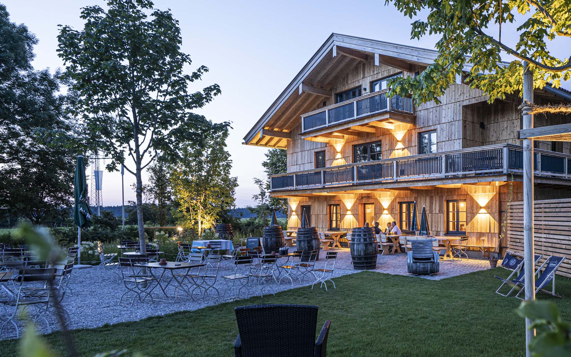 Die Biergartenmöbel stehen vor einem Hotel auf der Terrasse.