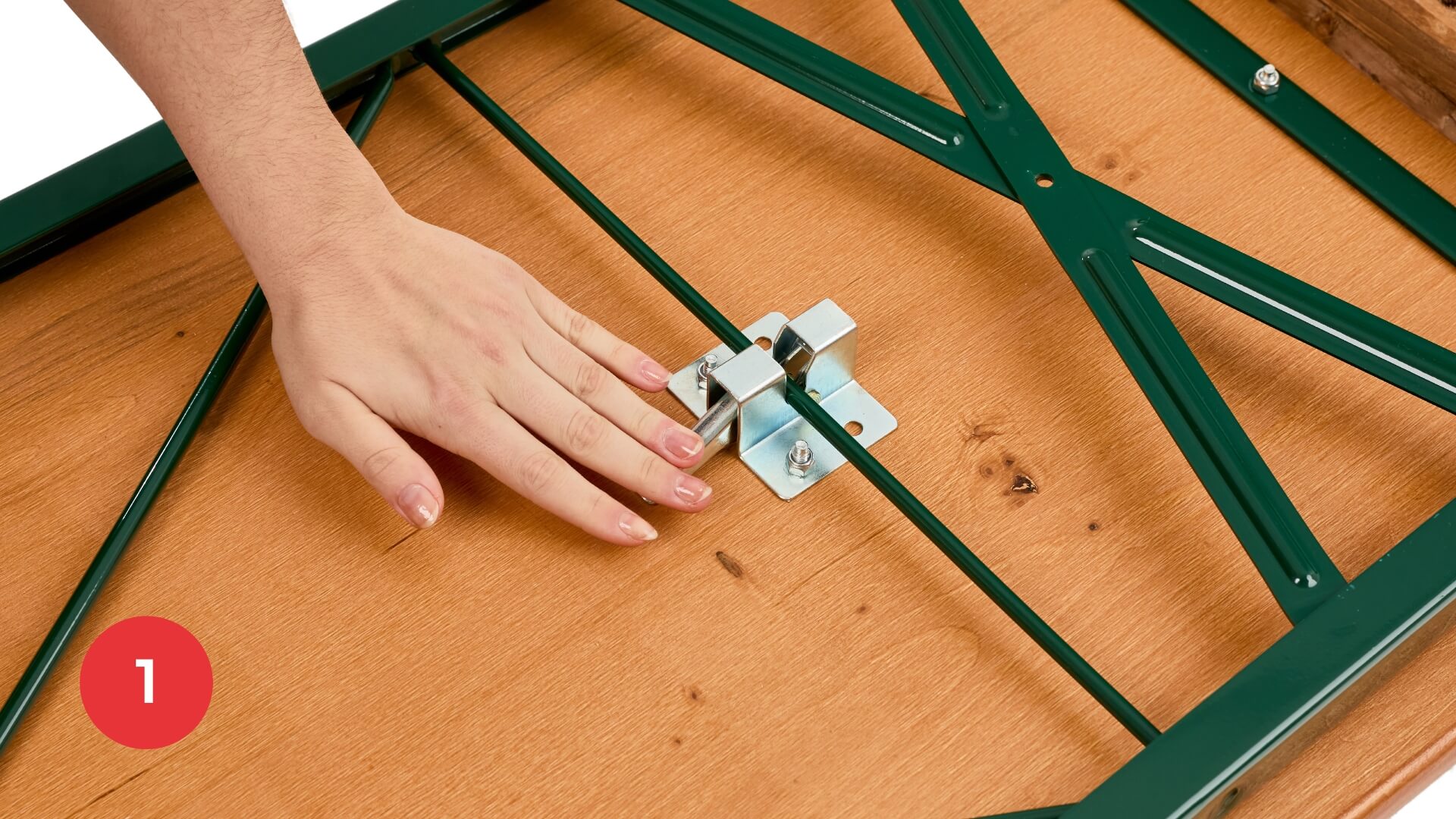 Hand auf dem Klappmöbelschloss der klassische Bierzeltgarnitur Eine Hand drückt den Hebel des Klappmöbelschlosses nach unten, um die klassische Bierzeltgarnitur aufzubauen.