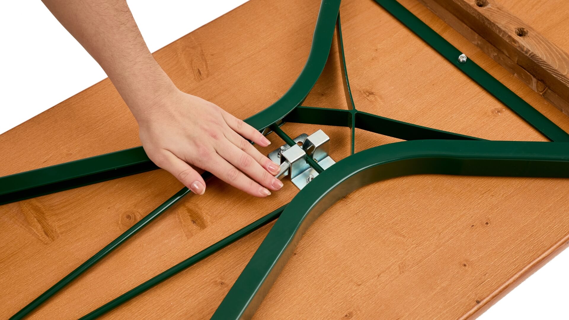 A hand pushes down the lever of the folding furniture lock to assemble the beer garden table set with legroom.