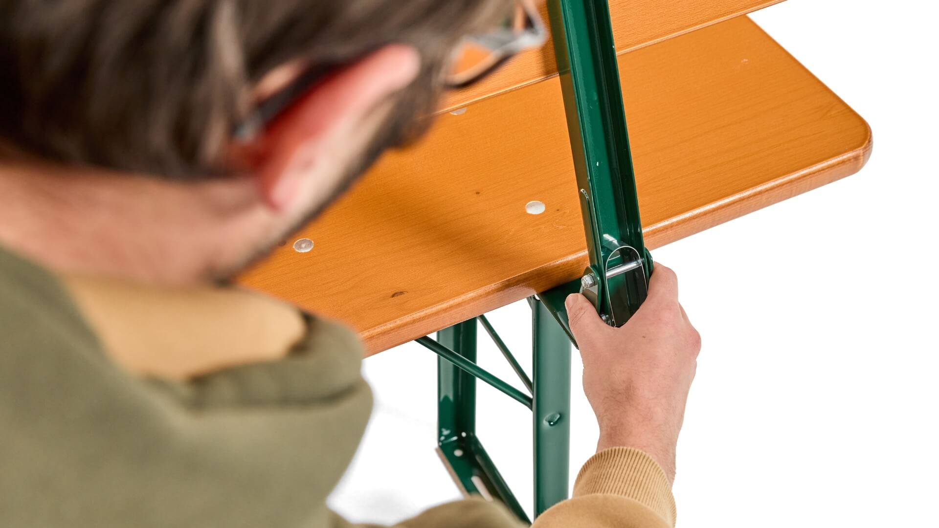 A boy presses the bolt at the back of the classic beer garden table set to be able to fold the back.