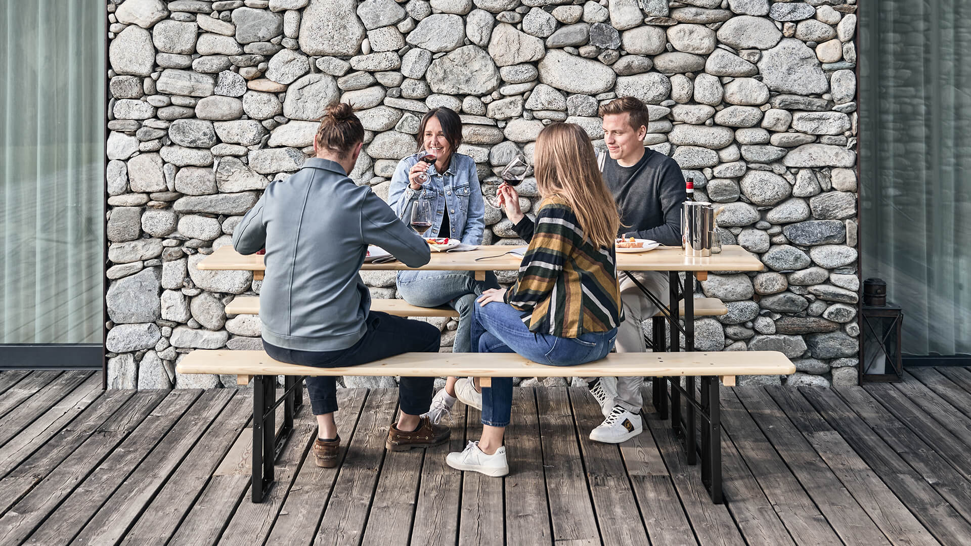 4 Personen genießen Ihre Mahlzeit auf einer klassischen Bierzeltgarnitur in Natur. 