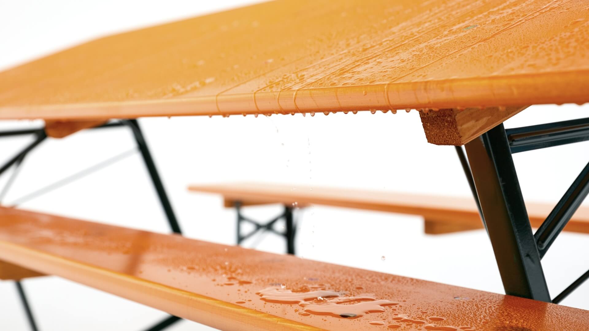 Water drains from a classic beer garden table set as the set stands at an angle.