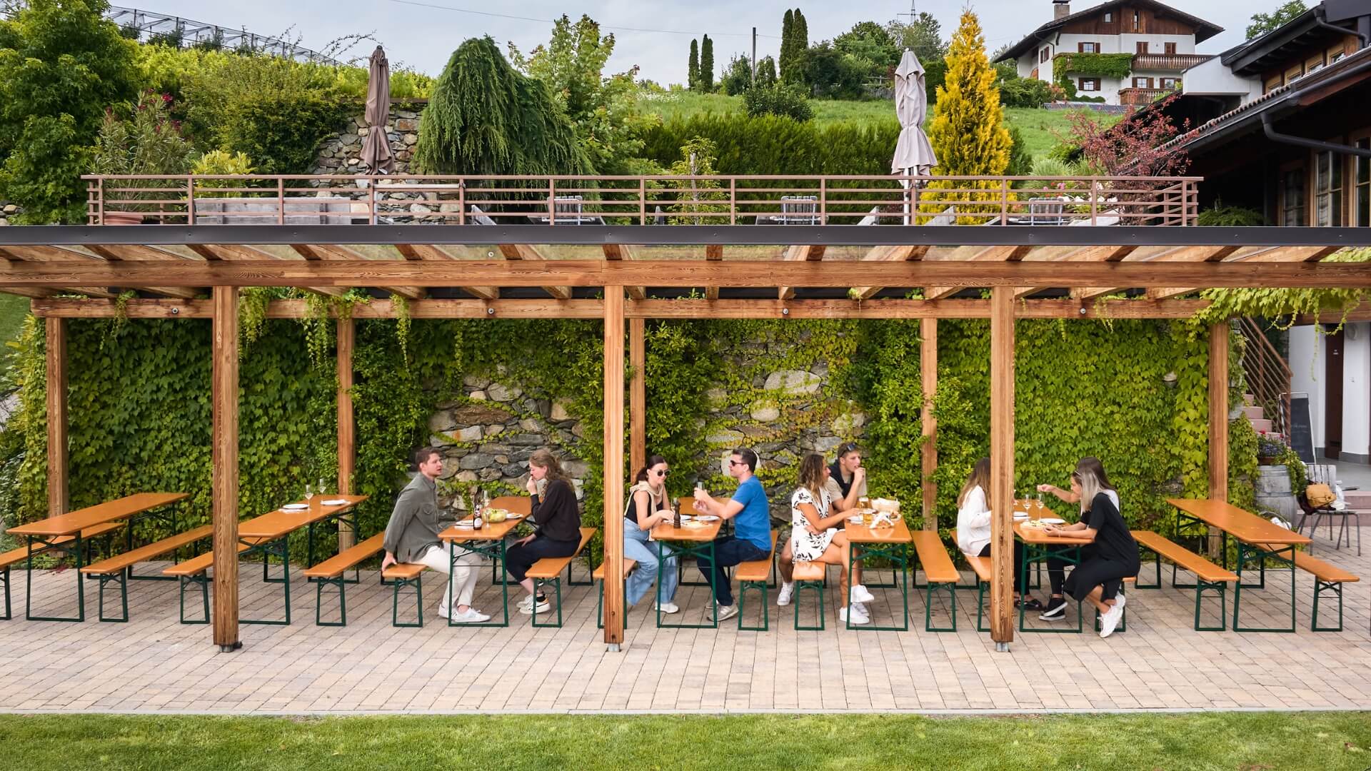 Several people have taken a seat on the classic beer garden table sets at the Guggerhof.
