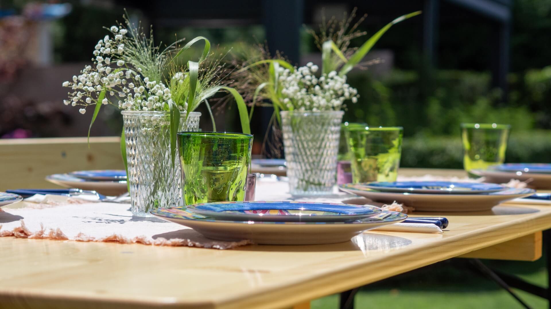 The wide beer garden table set in nature has been lovingly decorated for a meal in the garden.