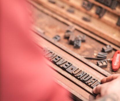 Die Buchstaben von RUKU EVENT werden für den Brennstempel vorbereitet.