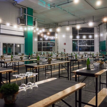Die Stehtische sind in einer Halle aufgestellt und für ein Catering dekoriert.