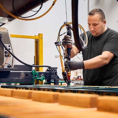 Im Bild werden in der Werkstatt in Schabs die Untergestelle und Verschlussmechanismen der RUKU1952-Bierbänke montiert.