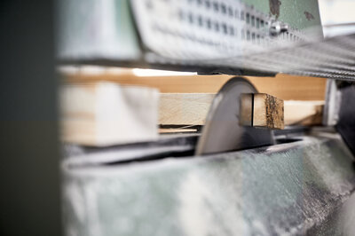 A close-up shows how wooden panels for beer tent sets are cut. 