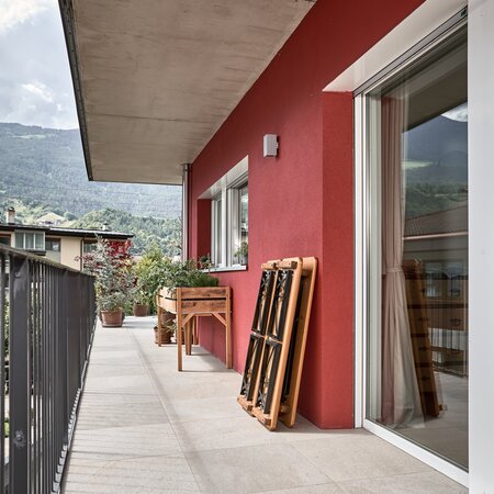 Auf einem Balkon ist die kleine Bierzeltgarnitur Shorty zusammengeklappt und gegen die Wand gestellt.