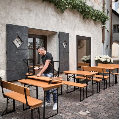 Ein Mann baut die kleine Bierzeltgarnitur "Shorty" ab, um sie zu lagern.