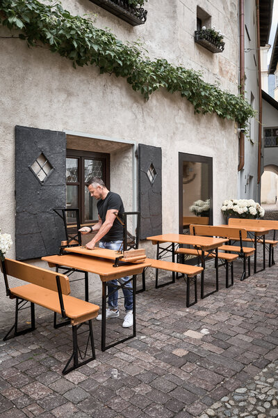 A man dismantles the small beer garden table set "Shorty" to store it.
