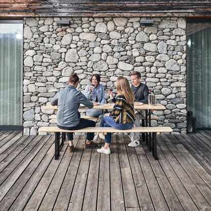 4 Personen genießen Ihre Mahlzeit auf einer klassischen Bierzeltgarnitur in Natur. 