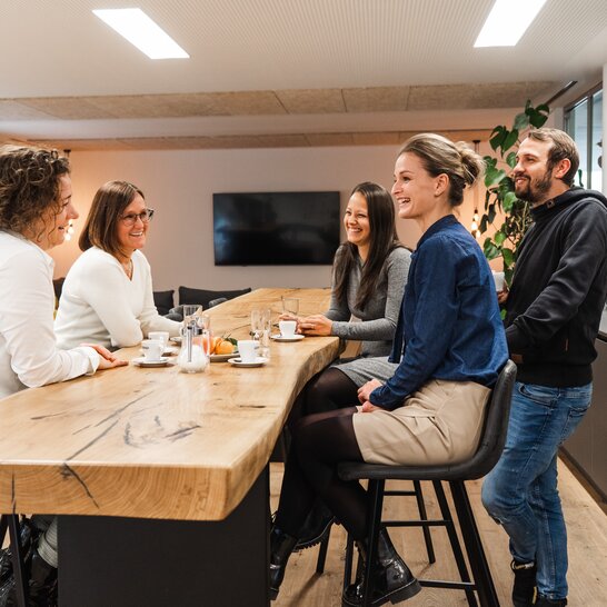 Employees of the Zingerle Group are sitting in the break room, enjoying a coffee and fresh fruit that is delivered several times a week.