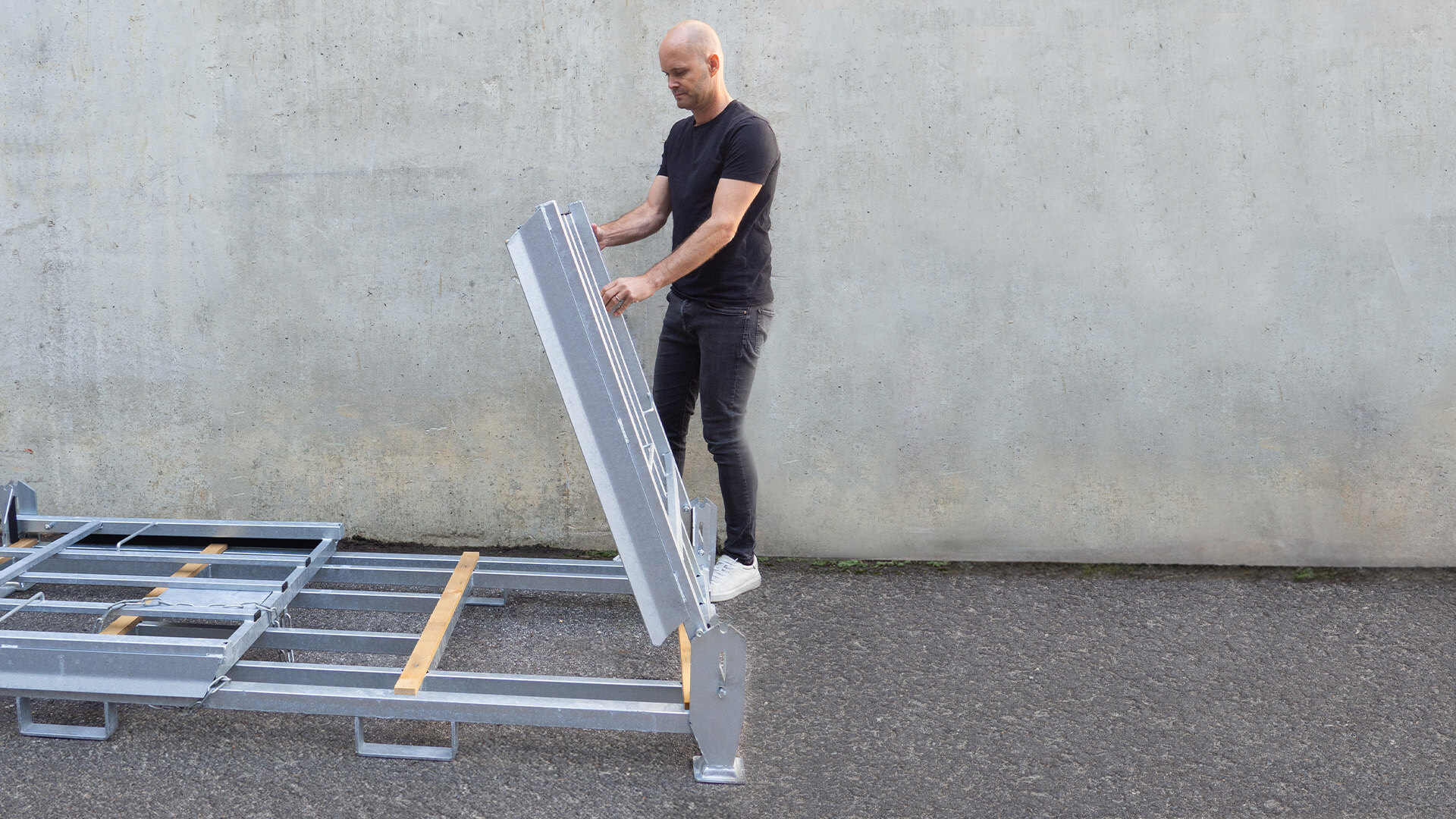 Seitenteile der Transportbox | 15er Set Ein Mann öffnet die Seitenteile der Transportbox.
