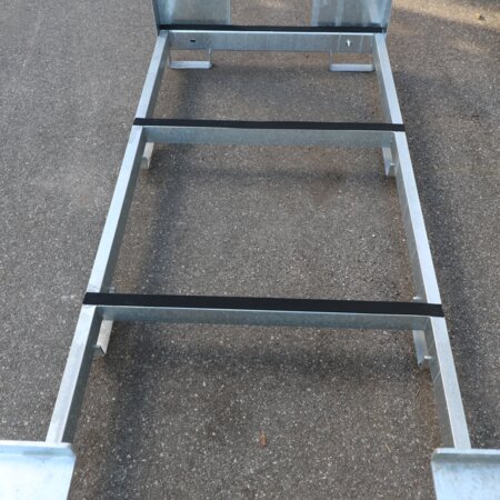 Auf dem Foto wurde das Innere eines leeren Transportgestells für Bierzeltgarnituren fotografiert. Man sieht die gepolsterten Querstreben an der Unterseite der Transportbox.