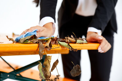 A woman removes the leaves on the beer garden table set.