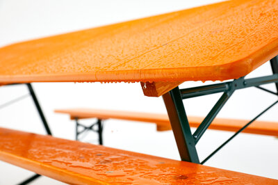 Water drains from a classic beer garden table set as the set stands at an angle.