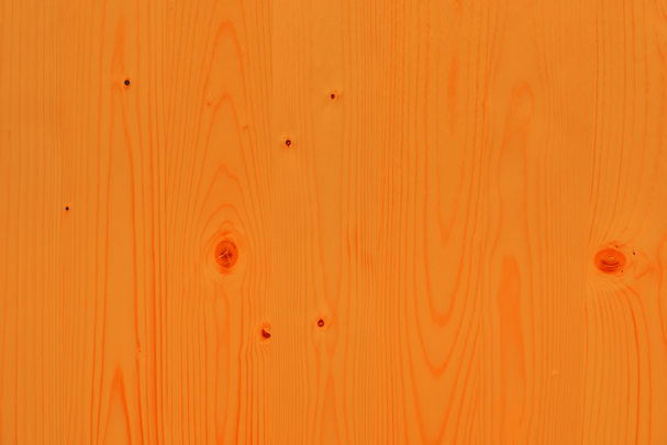 Man sieht eine Detailaufnahme des Holzes einer Bierzeltgarnitur in der Farbe Orange.