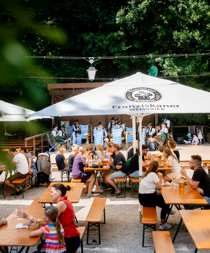 Bierzeltgarnituren mit Beinfreiheit sind in Biergarten Hirschau aufgebaut.