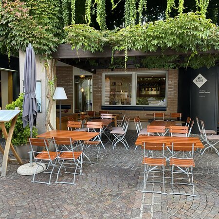 Quadratische Biergartenmöbel sind auf der Terrasse von Hotel Krone aufgestellt.