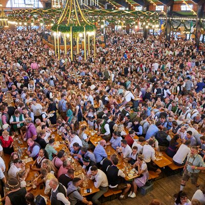 Beim Oktoberfest sitzen die Personen auf den Bierzeltgarnituren mit Beinfreiheit.
