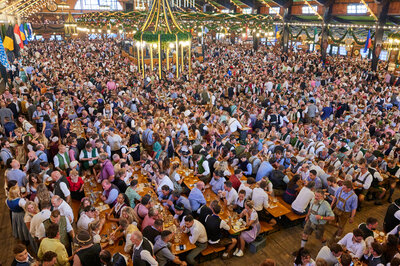 Beim Oktoberfest sitzen die Personen auf den Bierzeltgarnituren mit Beinfreiheit.