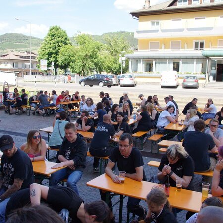 Bei dem Rookies & Kings Event sitzen viele Leute draußen auf Bierzeltgarnituren und unterhalten sich.