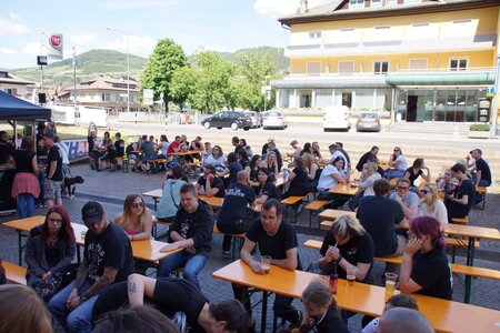  At the Rookies & Kings event, many people sit outside on beer table sets and chat.